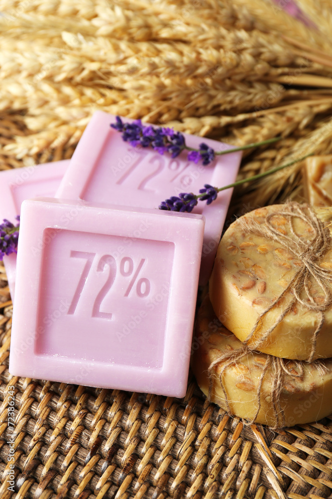 Bars of natural soap on wicker mat, on light background Bars of natural soap on wicker mat, on light background