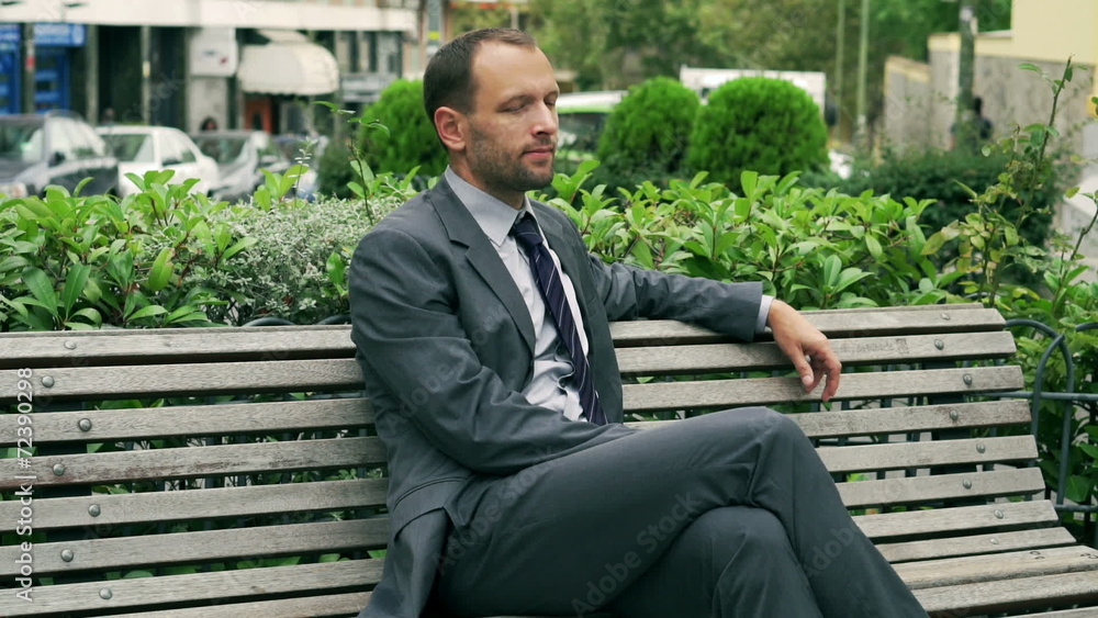 Businessman sitting and relaxing on the street bench Businessman sitting and relaxing on the street bench