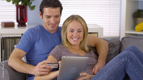 Happy couple buying something online with tablet