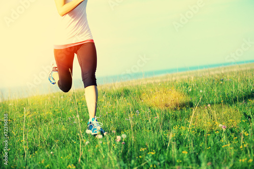 Runner athlete running on seaside green grass