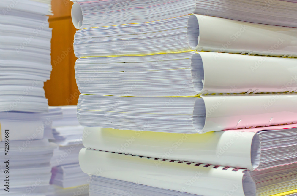Fototapeta premium Pile of documents on desk stack up high waiting to be managed