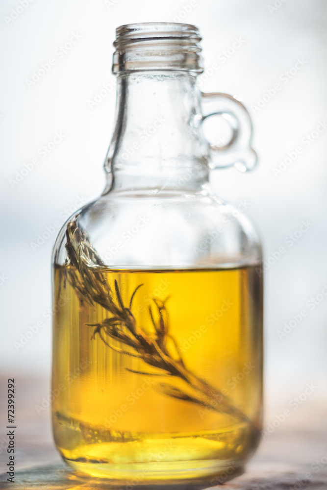 Bottle of olive oil with green rosemary sprig