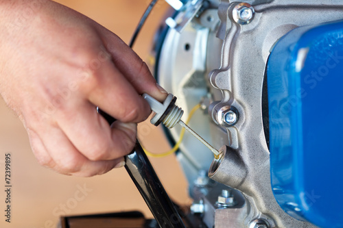 Checking the oil level on a small combustion engine