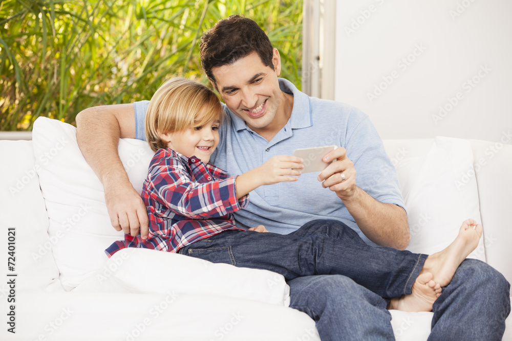 Vater und Sohn auf dem Sofa, machen Selfies Vater und Sohn auf dem Sofa, machen Selfies