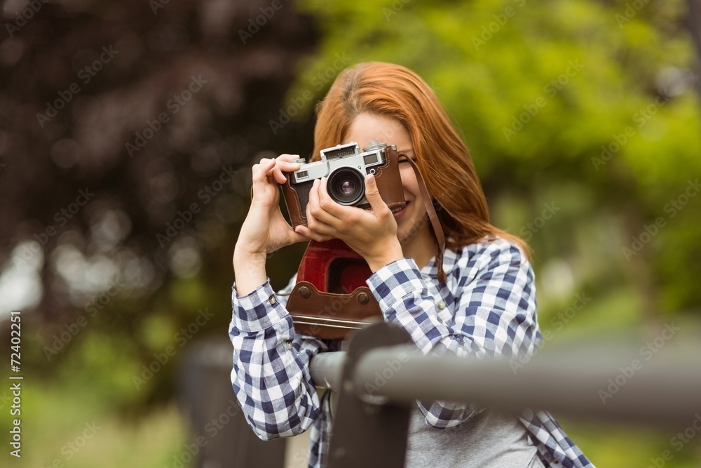 Smiling young woman taking a photo at camera Smiling young woman taking a photo at camera
