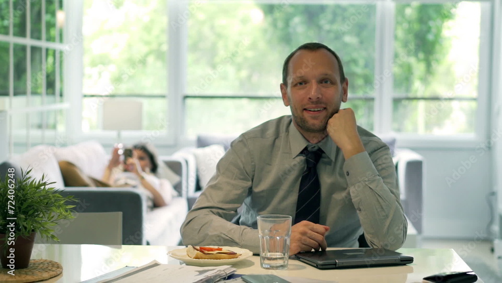 Happy businessman sitting at home and smiling to the camera Happy businessman sitting at home and smiling to the camera