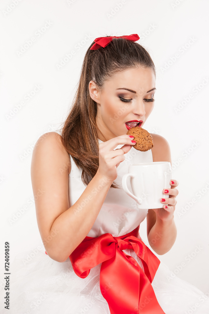 Portrait of a woman eating christmas cookie and holding a mug Portrait of a woman eating christmas cookie and holding a mug