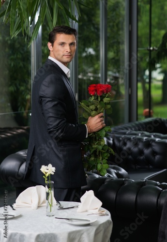 Handsome man with bunch of red roses 