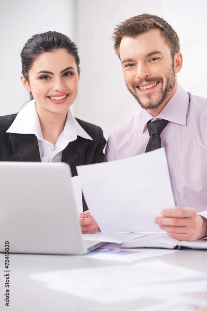 Cheerful business people sitting at table with laptop. Cheerful business people sitting at table with laptop.