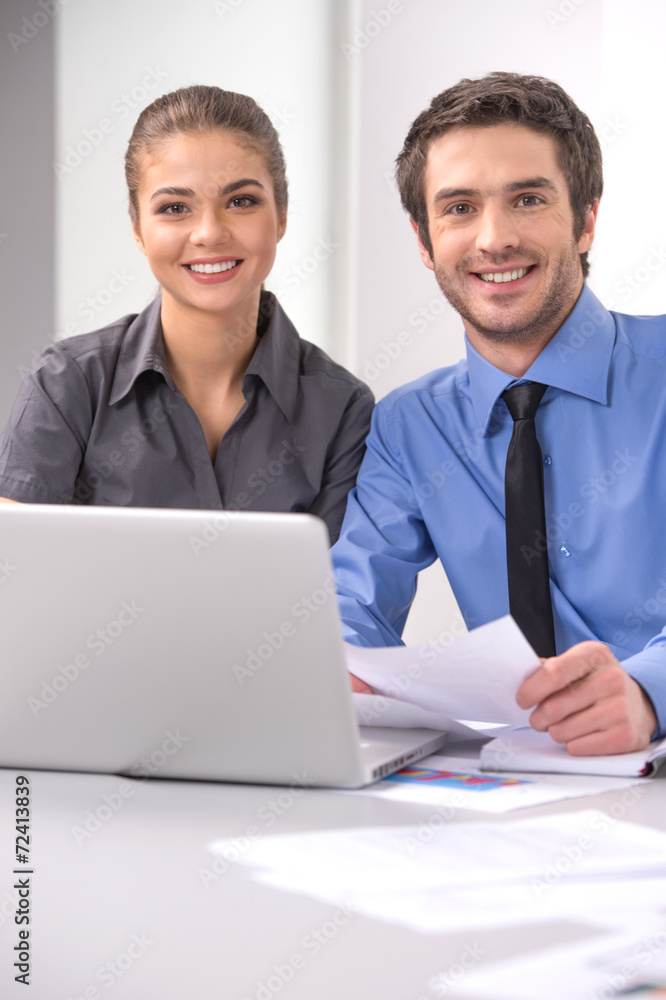 Cheerful business people sitting at table with laptop. Cheerful business people sitting at table with laptop.