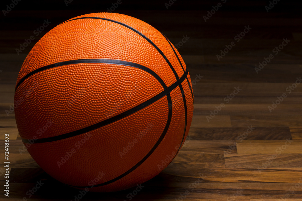 Obraz premium Basket ball sitting on wood floor