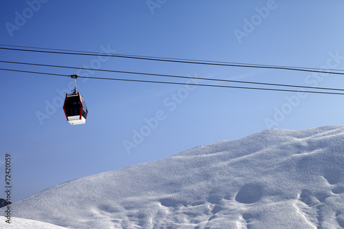 Gondola lift and off-piste slope at sun morning