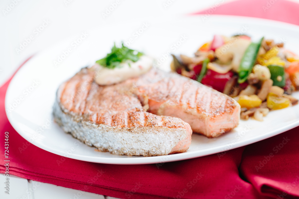 Grilled Salmon with Fresh vegetables on red background Grilled Salmon with Fresh vegetables on red background