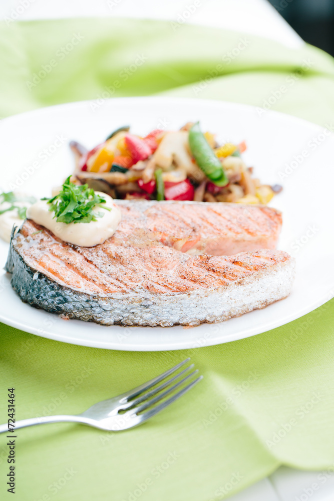 Grilled Salmon with Fresh vegetables on green background