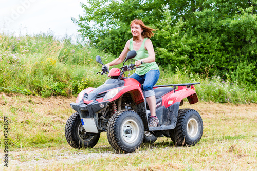 Frau fährt Off-Road mit Quad ATV durch Gelände 