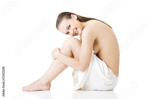 Sitting nude woman wearing towel