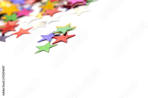 Christmas decoration of colored confetti stars against white bac