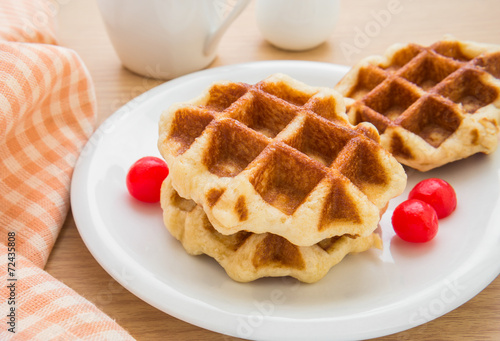 Waffles with cherries on plate