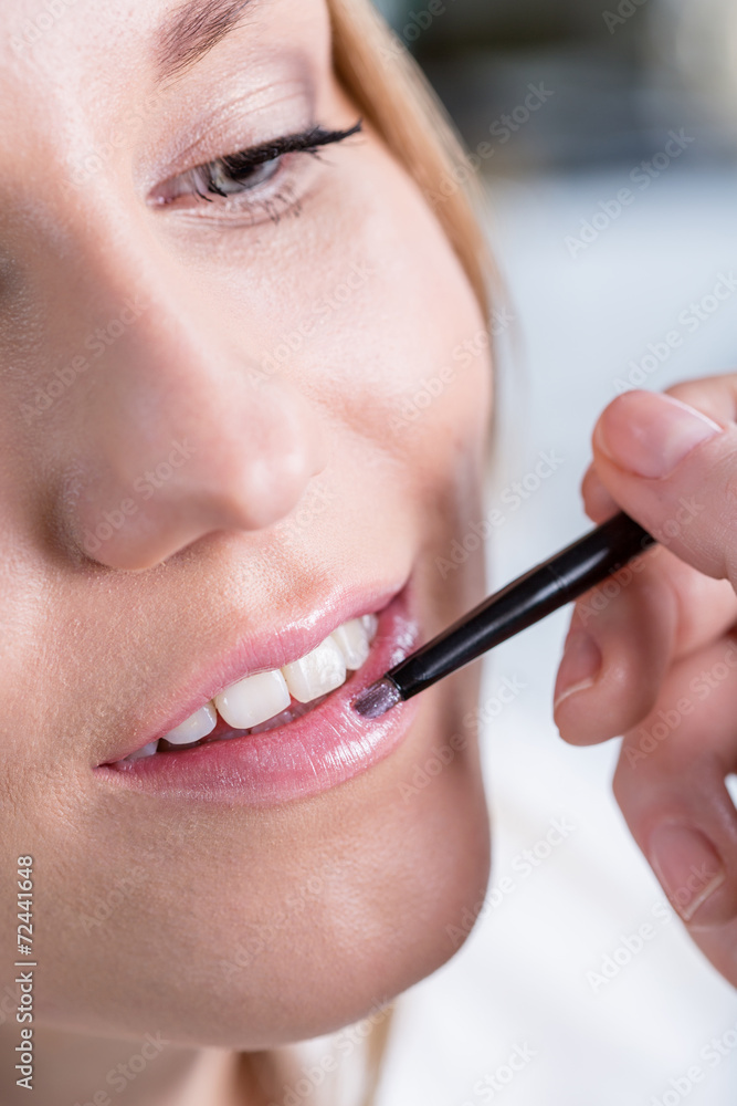 Woman during lips makeup