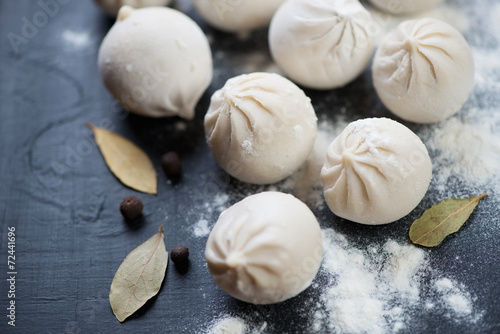 Raw khinkali with bay leaf and pepper, close-up, horizontal shot