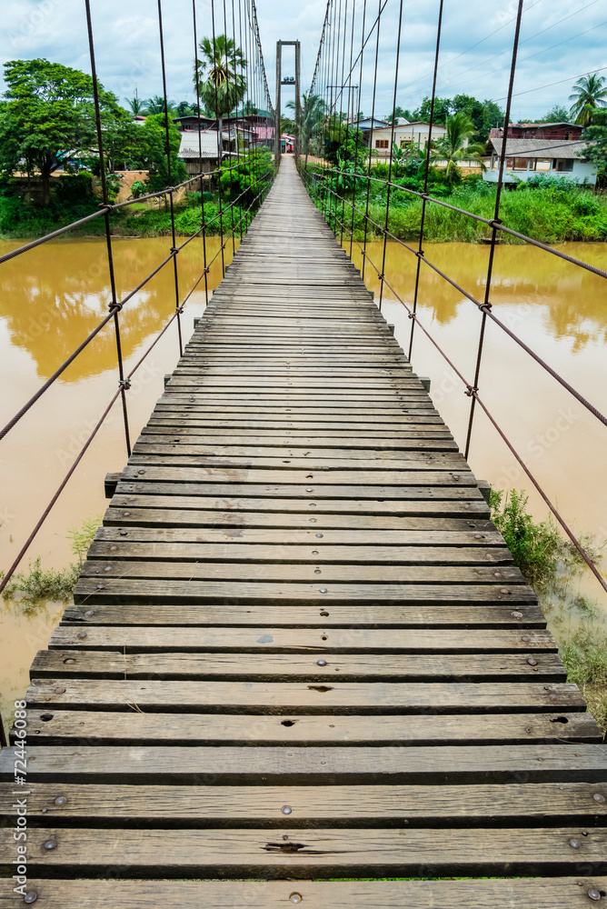 Rope suspension bridge across a river in flood, Thailand Rope suspension bridge across a river in flood, Thailand