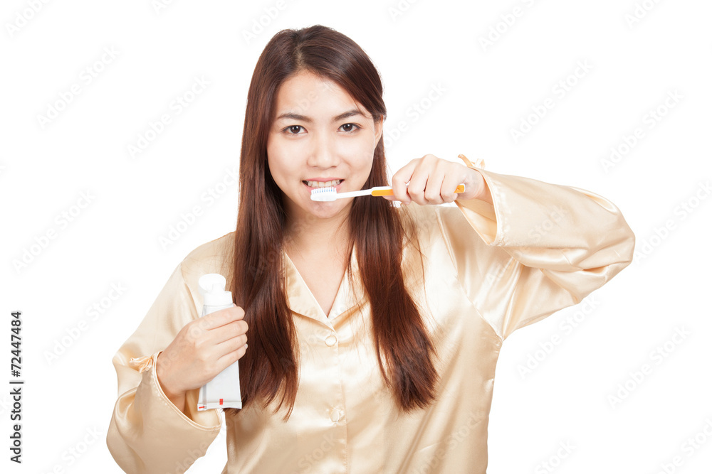 Asian woman in pajamas with toothbrush and toothpaste Asian woman in pajamas with toothbrush and toothpaste