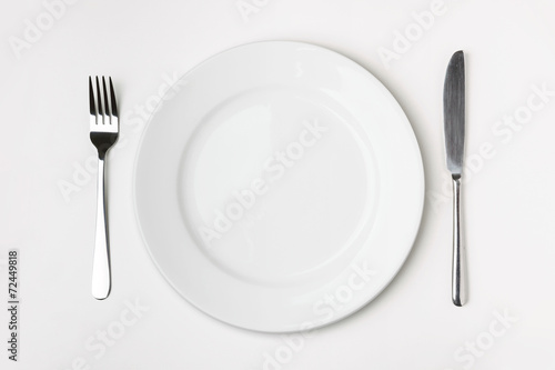 Knife  Fork and plate on table.