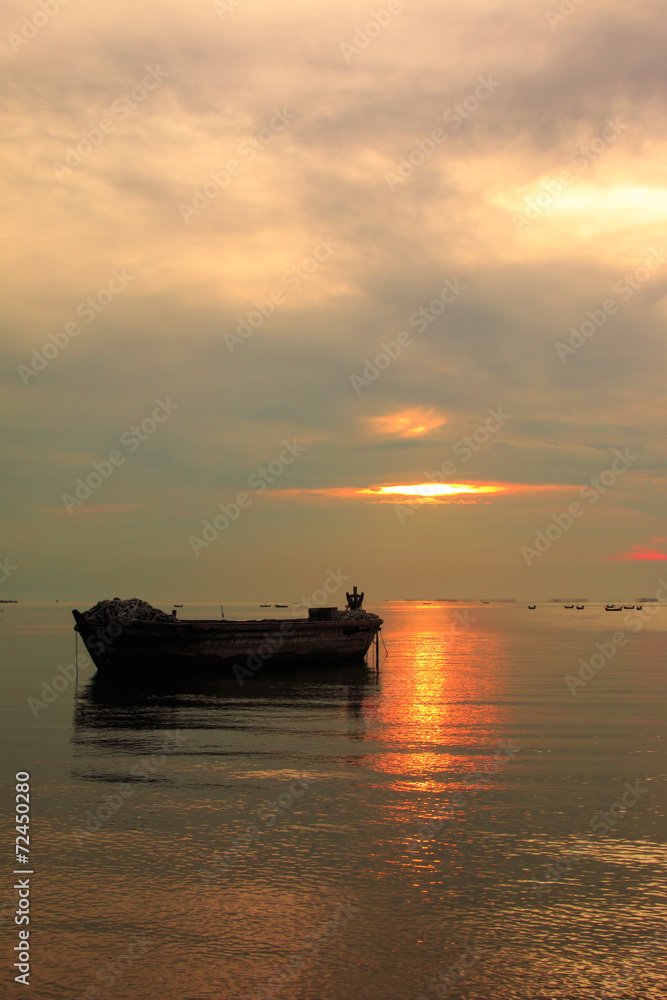old boat in front of sunset background near beach