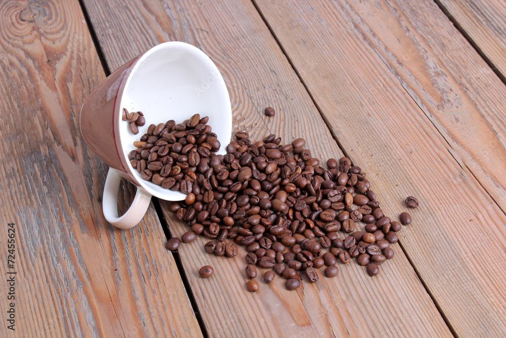 Cup with coffee beans on a wooden table Cup with coffee beans on a wooden table