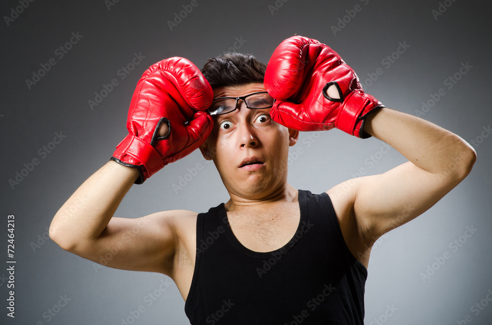 Funny boxer with red gloves against dark background Funny boxer with red gloves against dark background