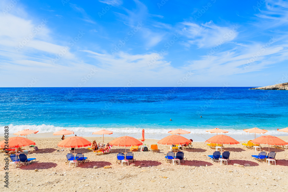 Row of umbrellas with sunbeds on Petani beach, Kefalonia island Row of umbrellas with sunbeds on Petani beach, Kefalonia island