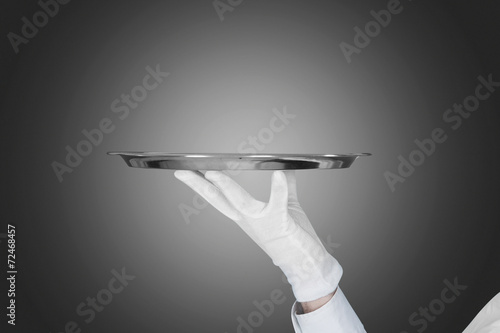 Waiter's Hand Holding Tray Over Gray Background