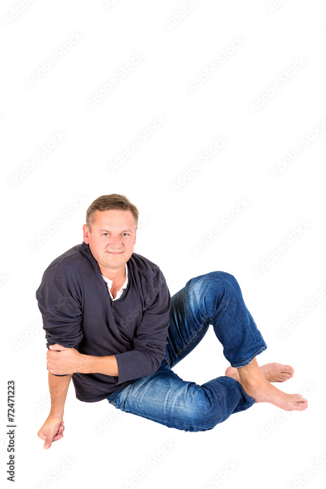 Casually dressed middle aged man barefoot on a floor Casually dressed middle aged man barefoot on a floor