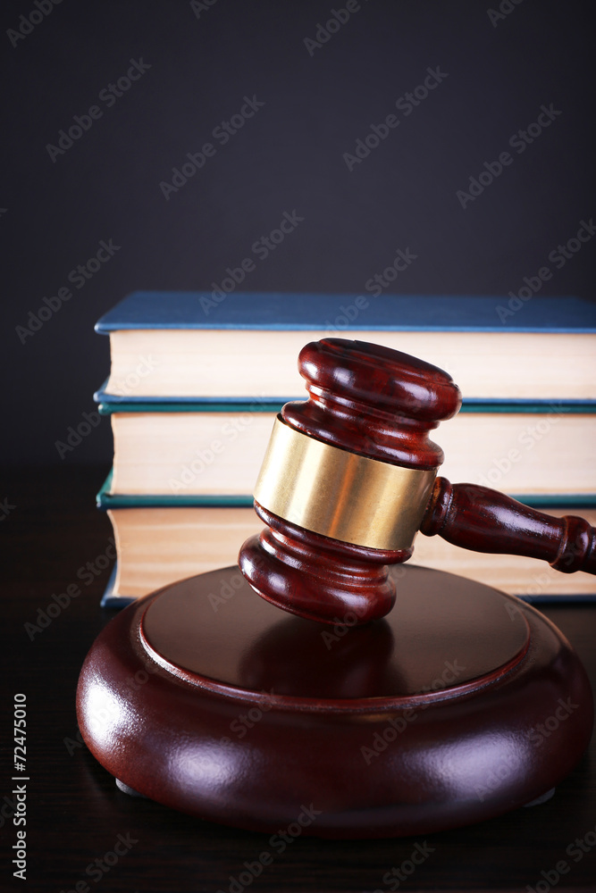 Judge's gavel and books on dark grey background