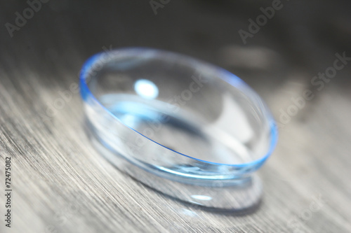 Contact lens with water drops on bright background