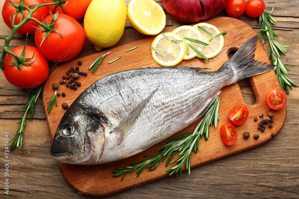 Fresh raw fish and food ingredients on table Fresh raw fish and food ingredients on table
