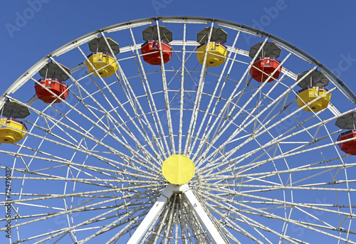 Colorful Ferris Wheel in amusement park with blue sky