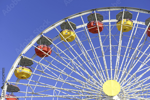 Colorful Ferris Wheel in amusement park with blue sky