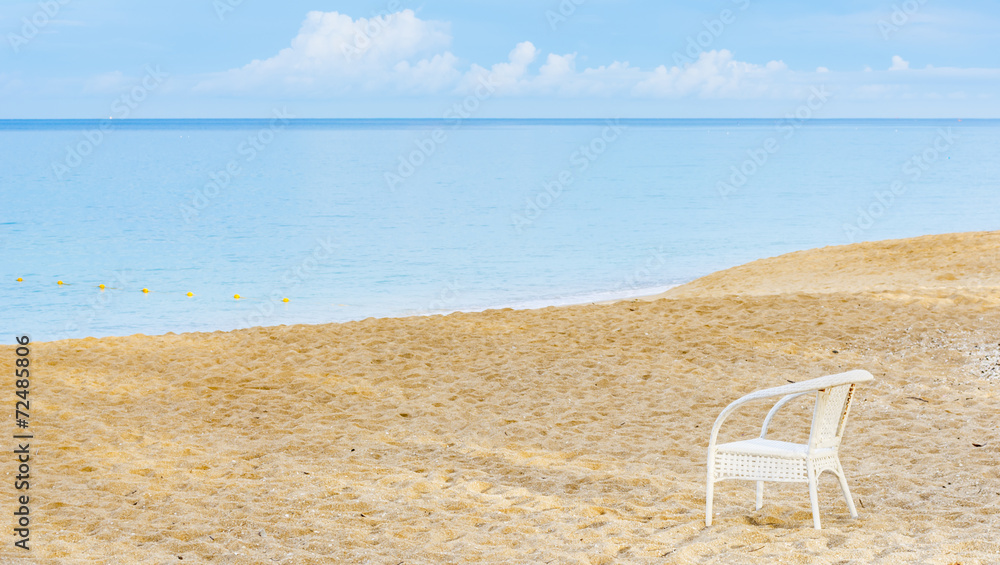 An empty chair on a sandy beach near the sea