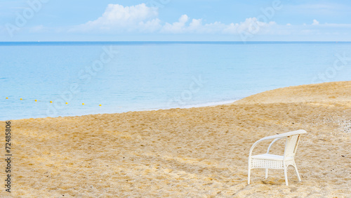 An empty chair on a sandy beach near the sea