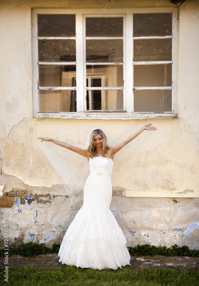 Fototapeta premium Blonde bride by old house
