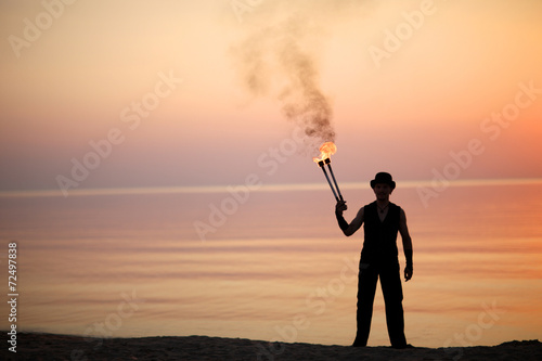 Fakir with fire torches photo