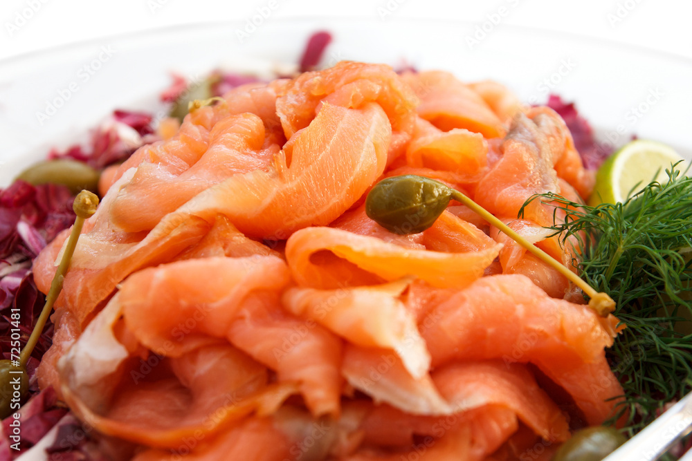 Plate of thinly sliced salmon on plate. Plate of thinly sliced salmon on plate.