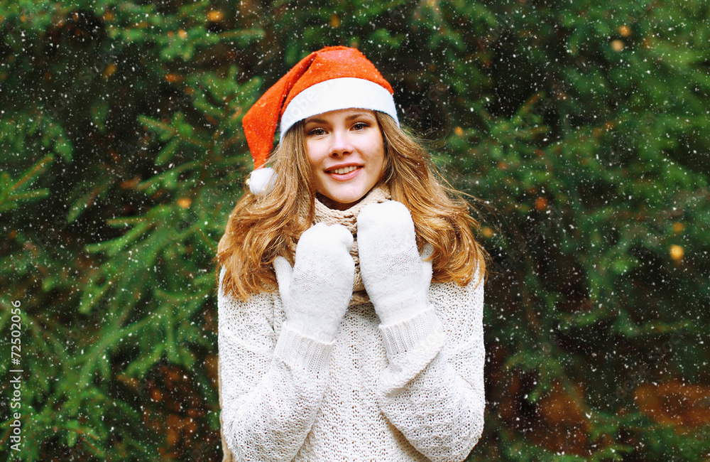 Christmas and people concept - happy young girl in winter hat ne Christmas and people concept - happy young girl in winter hat ne