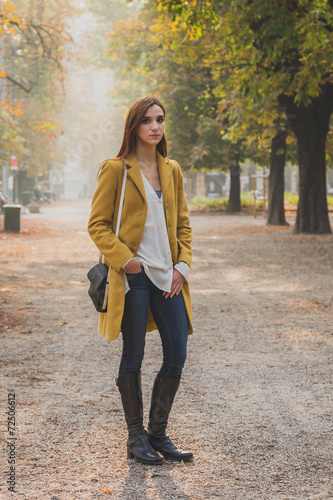 Redhead girl posing in a city park