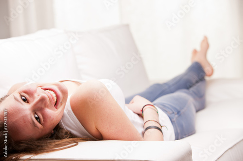 young happy girl lying on a sofa