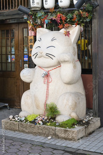 Obraz na plátně Maneki-neko - Large beckoning cat in front a store in Japan.