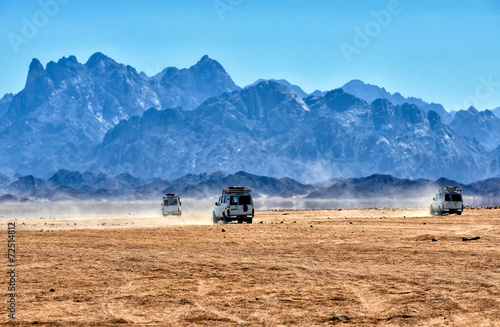 Landscape of Sahara desert with jeeps for safari.