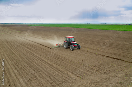 Farmer sowing crops at field with tractor