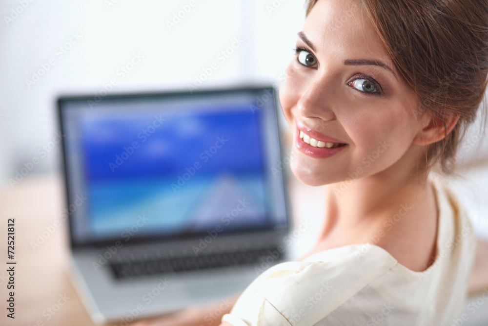 Portrait of a businesswoman sitting at desk with laptop Portrait of a businesswoman sitting at desk with laptop